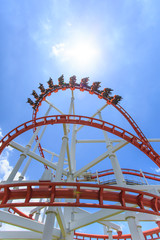 Red roller coaster rail with blue sky in background