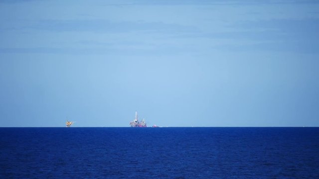 Jack up drilling rig in the middle of the ocean on sunny day
