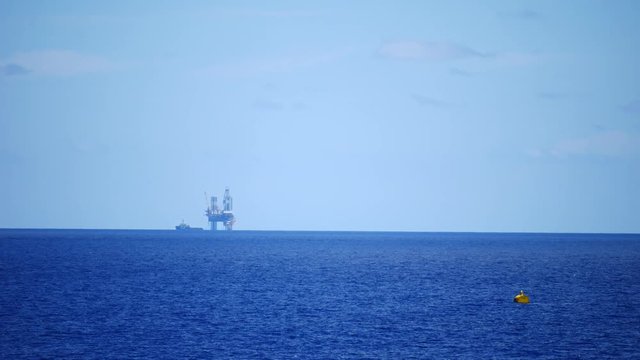 Jack up drilling rig in the middle of the ocean on sunny day
