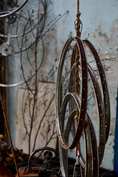 Steel bicycle wheels hang with rope and old wall background