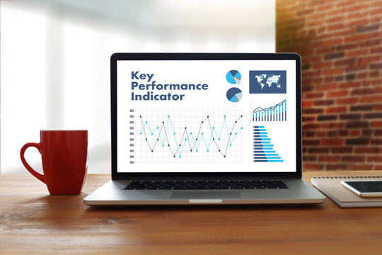 KPI Acronym (Key Performance Indicator) Business Team Hands At Work With Financial Reports And A Laptop