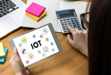 IOT business man hand working and internet of things (IoT) word diagram as concept