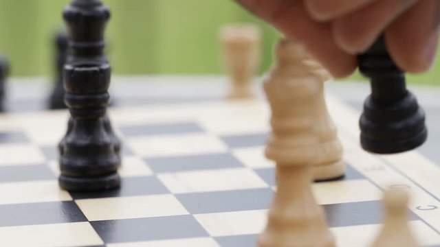 Close up of hand moving a chess piece and taking a position, in slow motion