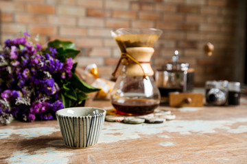 top view of ground coffee pouring water on coffee ground with filter, Flower and brick wall background, Colour Retro style. Copy space for your text. Thailand