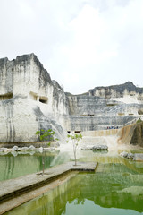 Fototapeta na wymiar Blue or green natural mineral lake, beautiful view of the white chalk limestone hill in Jaddih or Jeddih Hill, Madura Island, Indonesia