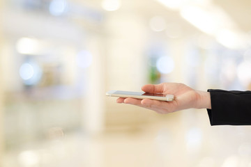 Businesswoman hands using smart phone over blur office with bokeh light background, banner, business on phone