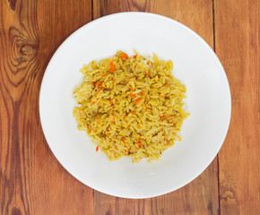 Rice cooked with carrots and spices on white dish