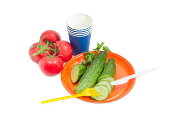 Disposable cutlery and several vegetable on a light background