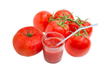 Fresh tomatoes and glass of tomato juice with drinking straw