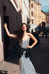 Beautiful fashionable lady posing on old street