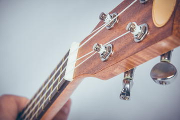 Part of an acoustic guitar on a grey background.