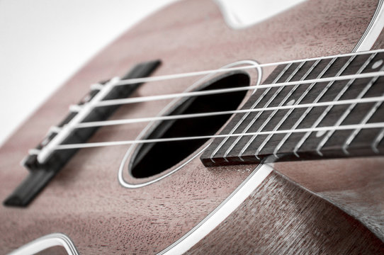 Part of an acoustic guitar on a grey background.