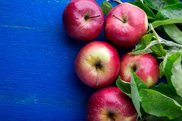 Red apples on blue wooden background. Top view. Copy space.