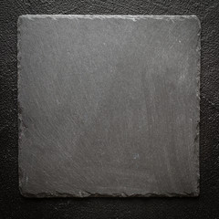 Black stone plate on black surface background