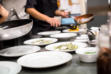 Restaurant kitchen with chefs preparing a meal