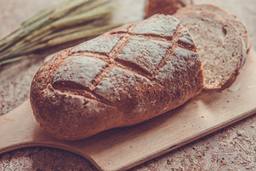 Bread slice on a wooden board. Wheat fresh loaf