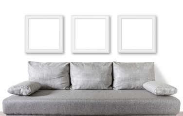 Three frames set over modern couch with cushions