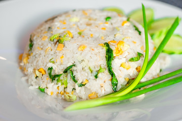 Rice with vegetables in a Thai restaurant close-up on a white plate