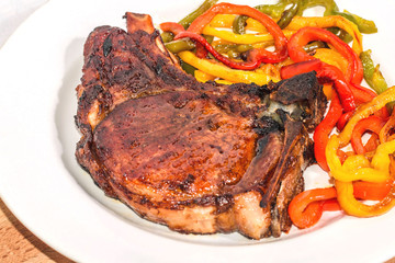 Delicious appetizing steak with vegetables on a plate on a wooden board, free, copyspace