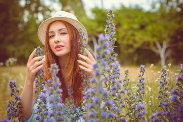 Beautiful and nice redhead woman in white hat in vacation spending a good time. Girl in white and pink light blue tones at clothes