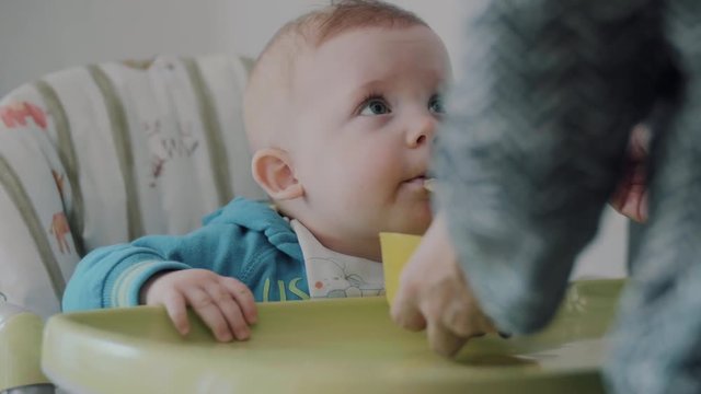 Mum Feeds the Child with a spoon. shot in slow motion