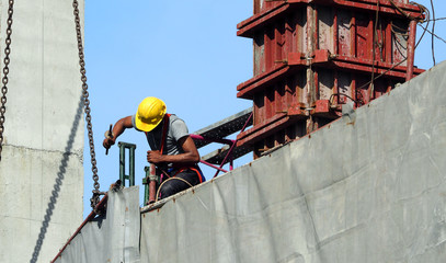 Labor man working on construction site with helmet.