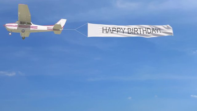 Small propeller airplane towing banner with HAPPY BIRTHDAY caption in the sky. 4K clip