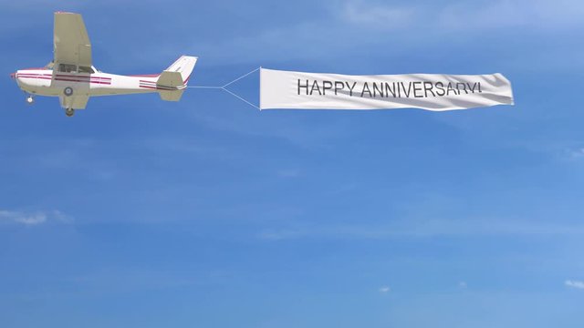 Small propeller airplane towing banner with HAPPY ANNIVERSARY caption in the sky. 4K clip