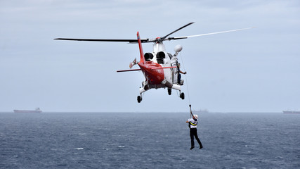 Pilot is disembarking from cargo ship by helicopter - 161104414
