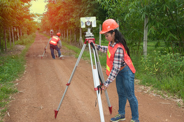 Surveyor or Engineer making measure by prism reflector with partner on the street in a field. - obrazy, fototapety, plakaty