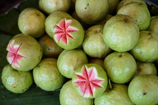 Fresh Green Guava Street Food With Pink Pulp And Seeds Selling On Banana Leaf In Local Market