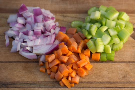 Diced Carrot, Onion, And Celery On A Wooden Cutting Board