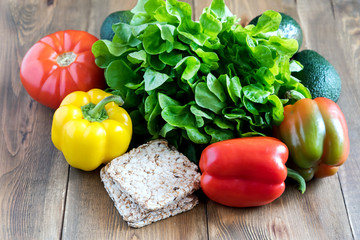 Fresh vegetables on wooden background Beautiful Yellow and red raw peppers Food for fasting days Ingredients for salad Crisp bread Diet or vegetarian food concept