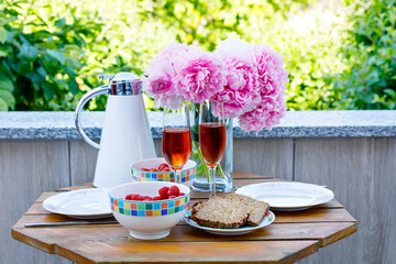 Breakfast table with bread, frest vegetables and berries, coffee and champagne served on balkony or hotel on summer morning