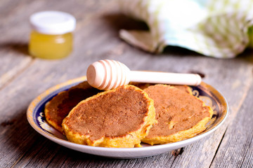 pancakes with pumpkin on a plate for breakfast with honey, horizontal