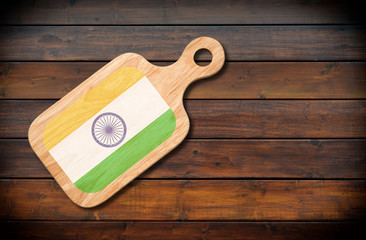 Concept of Indian cuisine. Cutting board with a India flag on a wooden background