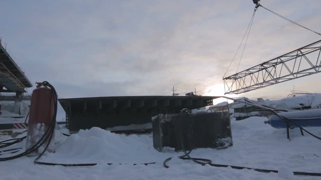 Construction Covered with Snow and Metal Beam Transported