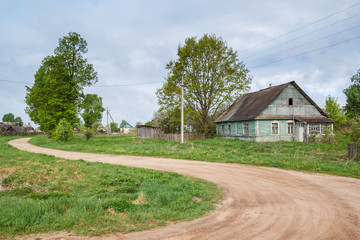 Obraz premium A dirt road with a green house in the summer