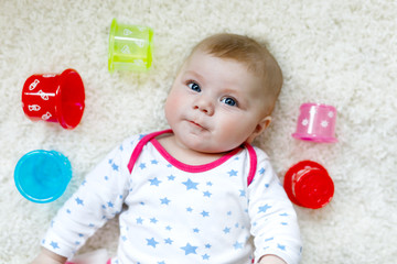 Cute adorable newborn baby playing with colorful educational rattle toy