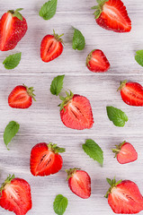 Colorful summer fruit background with slice strawberry and mint leaf, top view.
