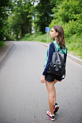 Sport girl at sportswear with backpack walking in a green park. A healthy lifestyle.