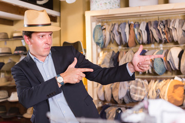 portret of smiling  guy try on  panama at headwear store © JackF
