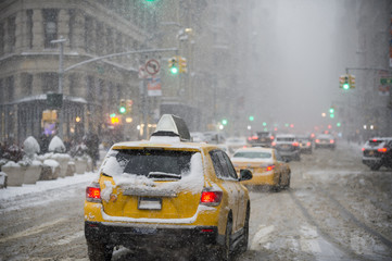 Een winterse sneeuwstorm brengt verkeer en voetgangers langzaam naar het Flatiron Building op Fifth Avenue.