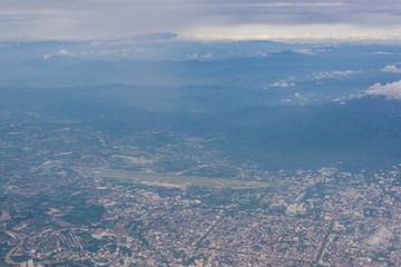 A cityscape with an airport in the scene view from the airplane window.