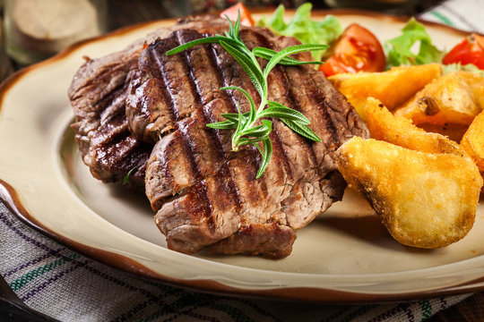 Succulent portions of grilled fillet mignon served with baked potatoes