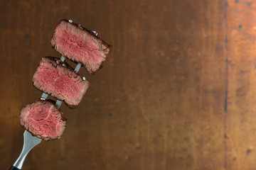 sliced steaks impaled on meat fork