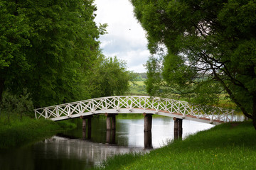 White wooden bridge in the old park in the village of Mikhailovskoye, Pskov region, Russia