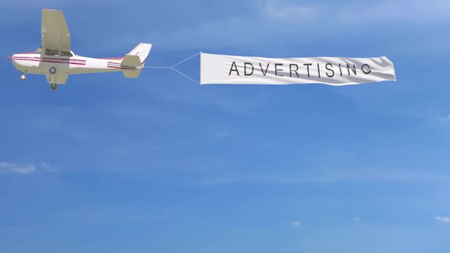 Small propeller airplane towing banner with ADVERTISING caption in the sky. 4K clip