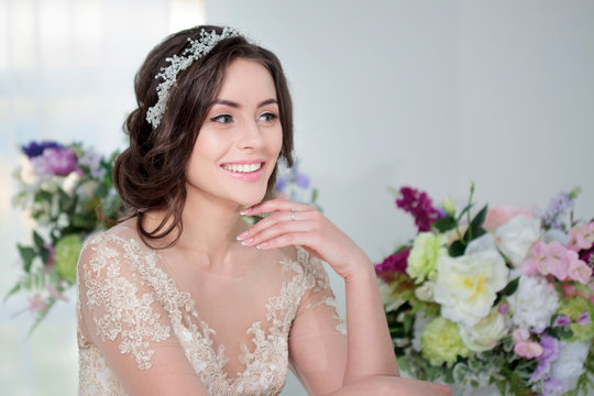 Portrait of beautiful girl in a luxurious wedding dress. Bride with beautiful decoration in her hair, smiling