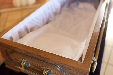 close up of open empty coffin in church